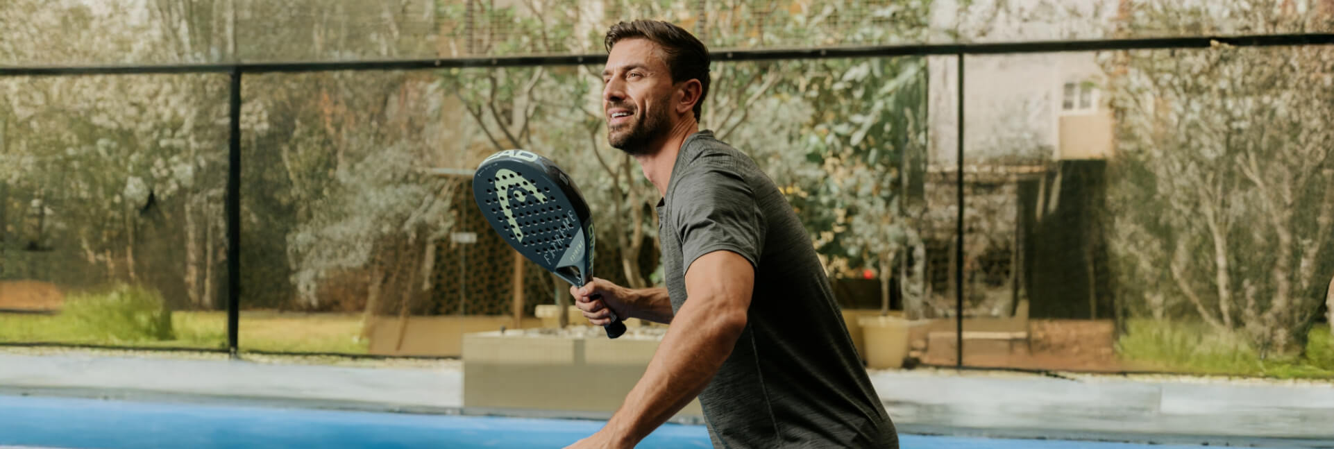 A man enjoying a game of padel on a blue court